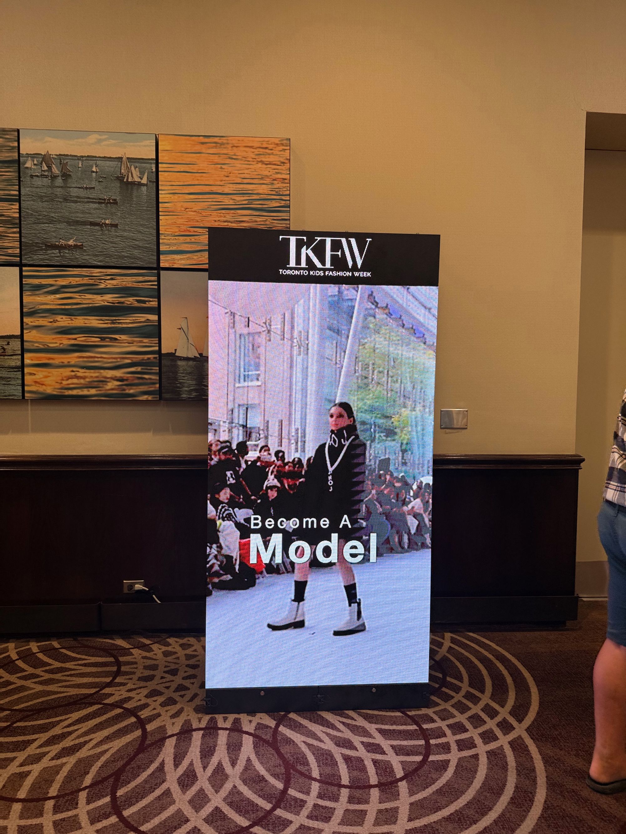 A freestanding portrait P2.6mm LED poster showing event content beside a registration area