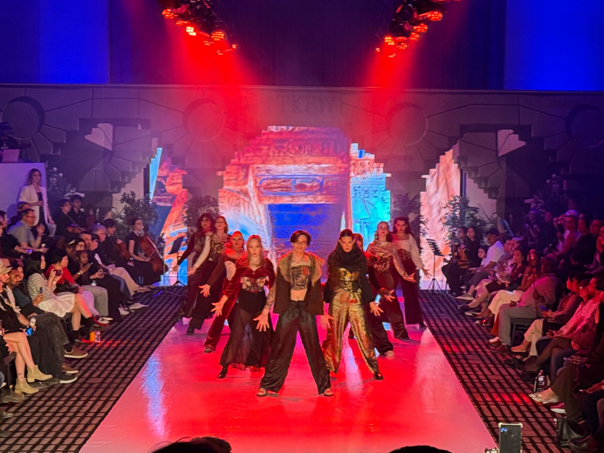 Runway performance lit in red with LED scenery behind the dancers