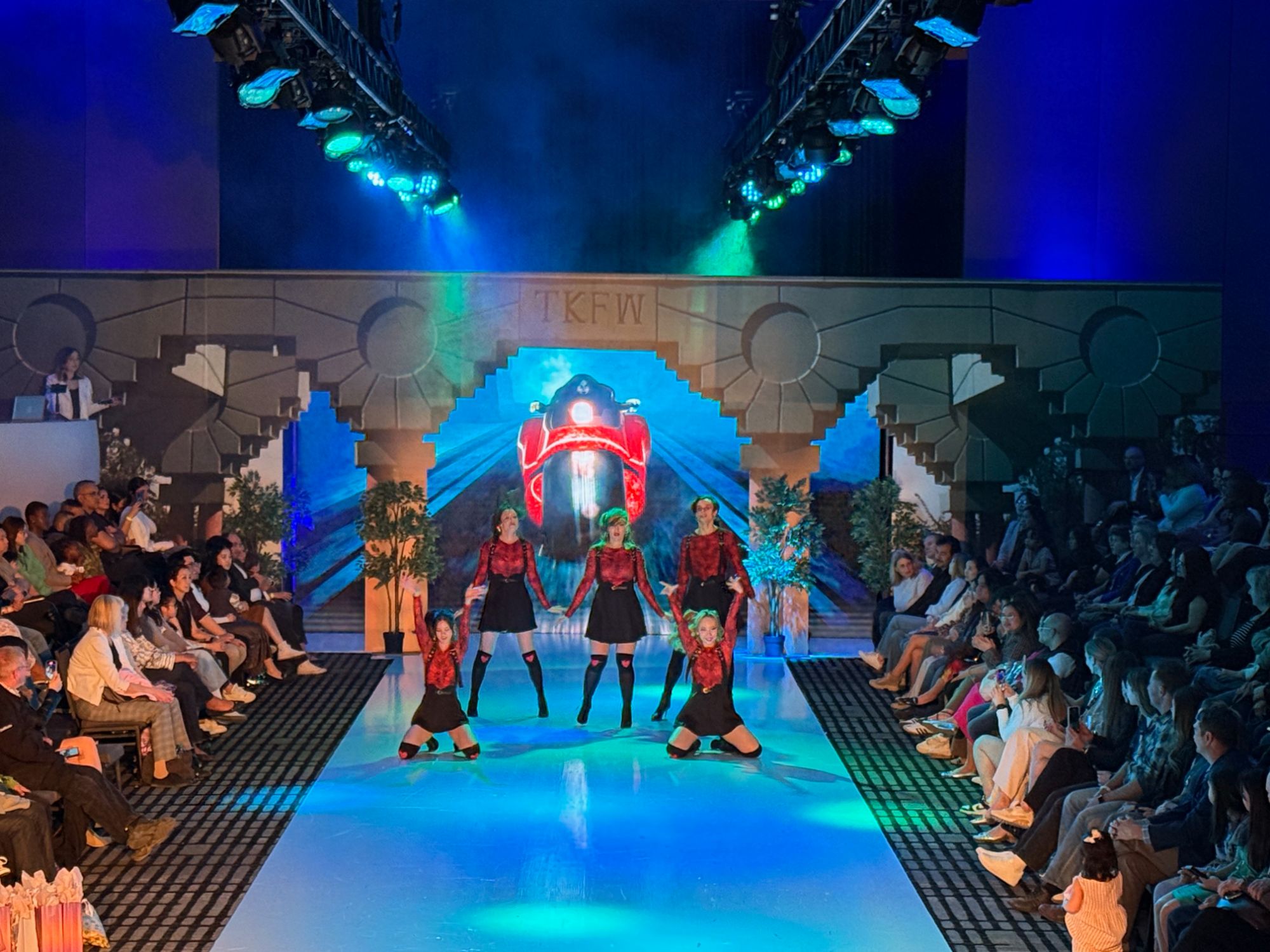 TKFW runway with stone gateway scenery on the LED wall and dancers mid-performance